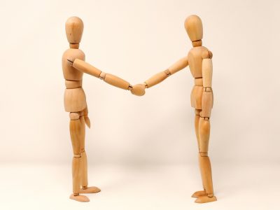 2 wooden people shaking hands